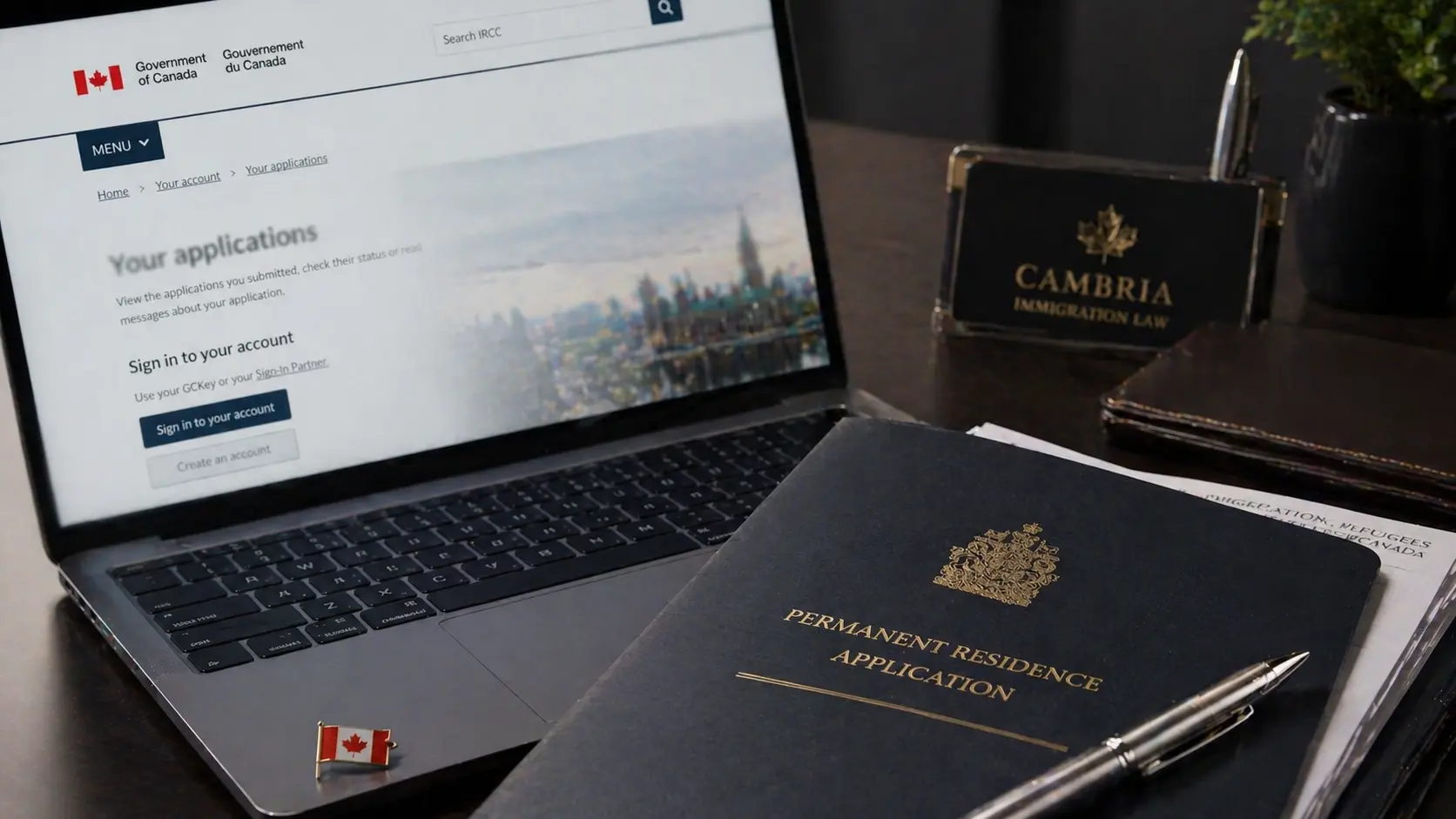 A desk featuring a laptop, official documents, and a Canadian flag pin, representing a successful Canadian Experience Class Express Entry application.